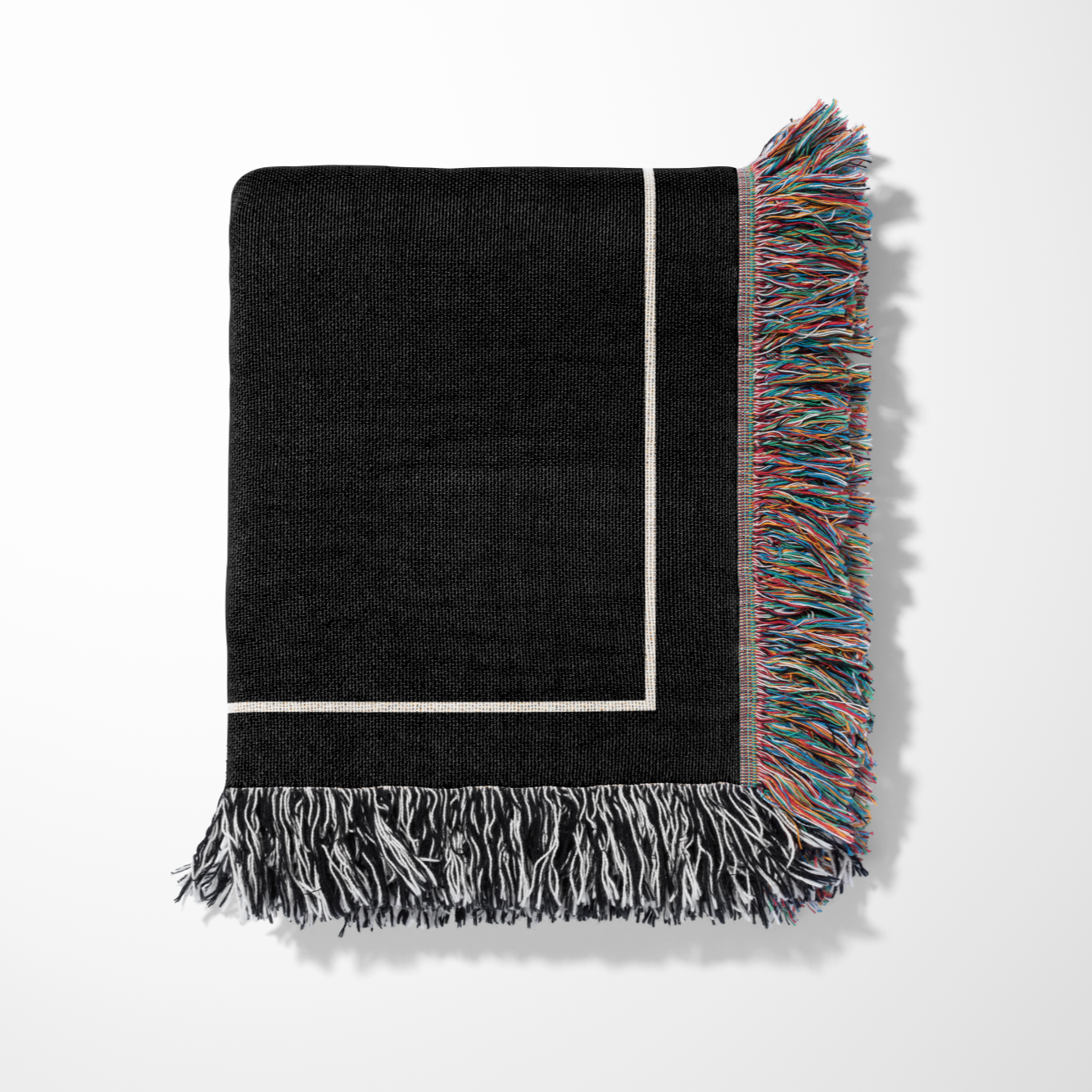 Custom cotton throw blanket folded up with a colorful fringe on a light gray background from The Blanket Shop