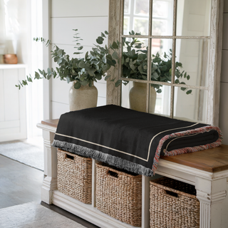 Custom woven throw blanket folded up on a modern side table entry way in a beautiful modern farmhouse for The Blanket Shop