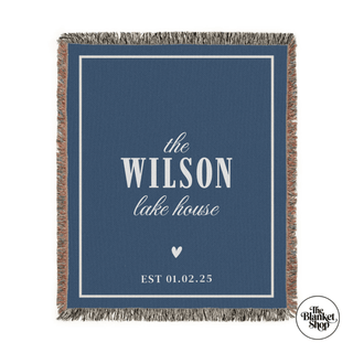 Blue blanket with 'the Wilson lake house' text and a heart symbol, featuring The Blanket Shop Logo