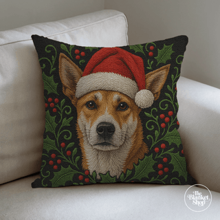 Custom throw pillow with a cute dog wearing a Santa hat on a white couch with The Blanket Shop Logo