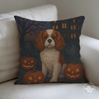 Custom throw pillow with a dog at halloween with pumpkins design on a white couch with The Blanket Shop Logo