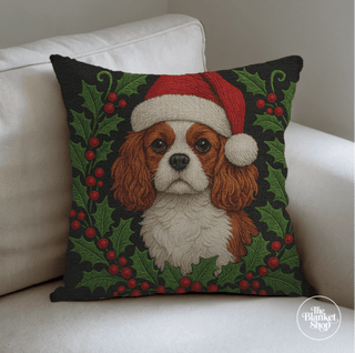 Custom throw pillow with a dog wearing a Santa hat on a white couch with The Blanket Shop Logo