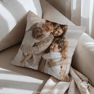 Custom throw pillow with a family photo on a couch, featuring 'The Blanket Shop' branding.