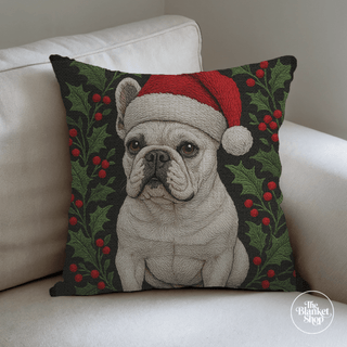 Custom throw pillow with a french bull dog wearing a Santa hat on a white couch with The Blanket Shop Logo