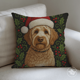 Custom throw pillow with a poodle mix dog wearing a Santa hat on a white couch with The Blanket Shop Logo