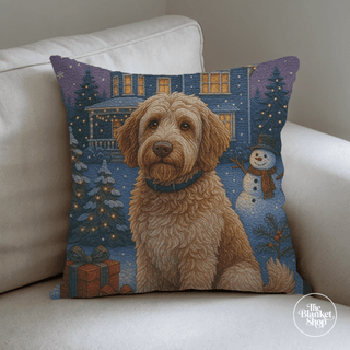 Decorative pillow with a dog and Christmas scene on a beige couch with The Blanket Shop Logo