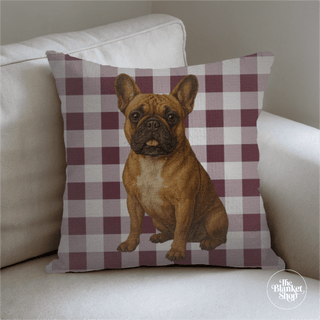 Decorative pillow with a dog illustration on a checkered pattern, placed on a couch with The Blanket Shop Logo