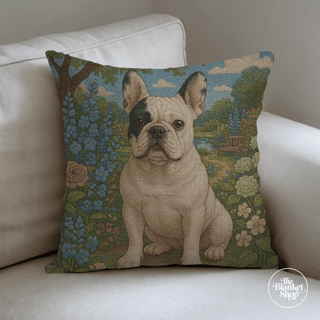 Decorative pillow with a french bulldog design on a floral background, placed on a white couch with The Blanket Shop Logo