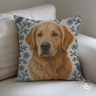 Decorative pillow with a golden retriever design on a beige couch and the Blanket Shop Logo