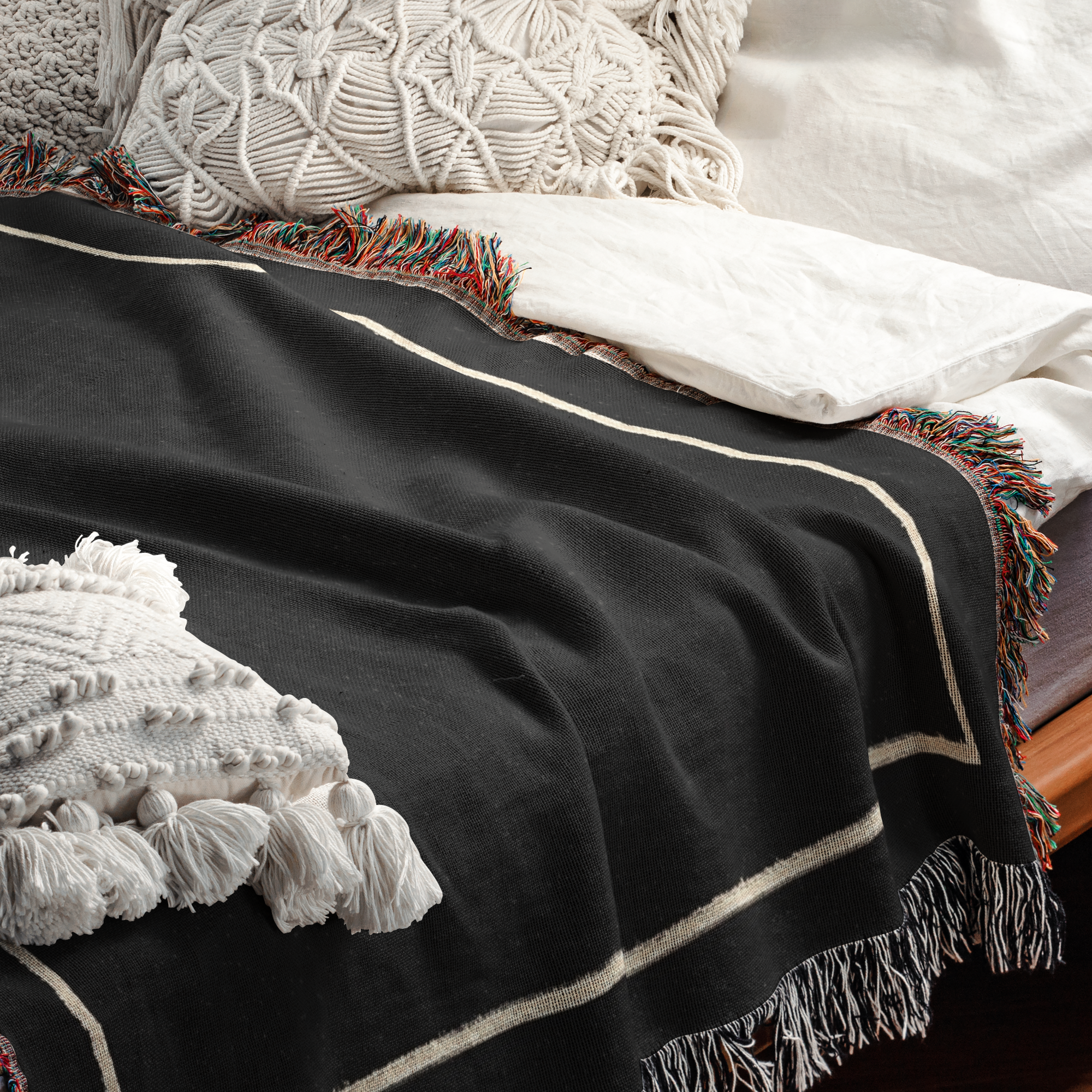 Decorative throw pillows and a custom woven blanket on a bed from The Blanket Shop