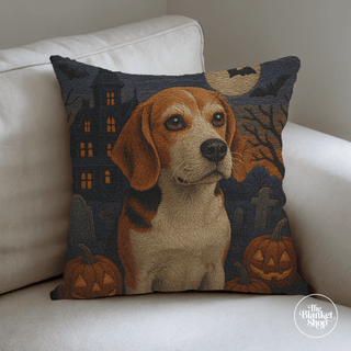 Halloween-themed pillow with a dog design on a white couch with The Blanket Shop Logo
