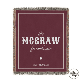 Personalized blanket with 'The Mcgraw Farmhouse' and a date on a maroon background