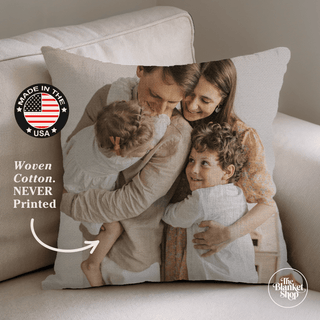 Personalized pillow with a family photo on a couch, featuring 'Made in the USA' and 'Woven Cotton' text and The Blanket Shop Logo
