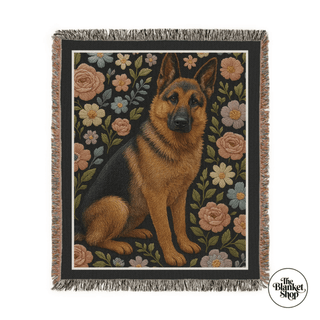 Woven blanket with a German Shepherd design and floral patterns, featuring 'The Blanket Shop' logo.