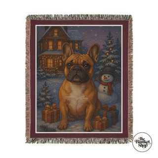 Woven blanket with a dog, Christmas tree, and snowman design on a white background with The Blanket Shop Logo