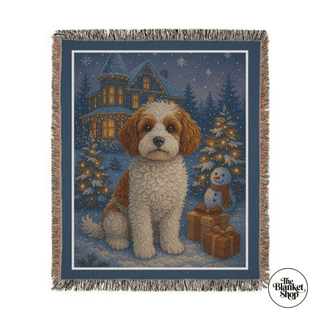 Woven blanket with a dog and Christmas scene design, featuring a house, trees, and snowman and The Blanket Shop Logo