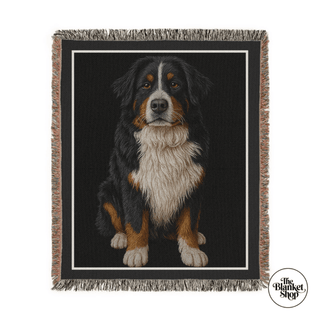 Woven blanket with a dog design on a black background, featuring 'The Blanket Shop' logo.