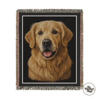 Woven blanket with a golden retriever design on a black background, featuring 'The Blanket Shop' logo.