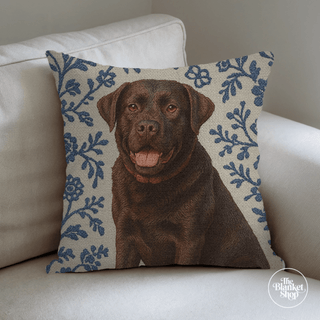 Decorative pillow with a chocolate Labrador design on a beige couch